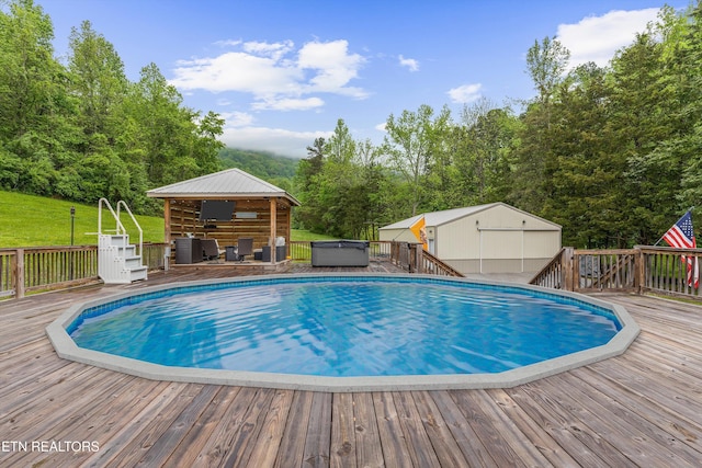 view of pool with a hot tub, a deck, and a fenced in pool