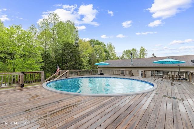 outdoor pool with a wooden deck