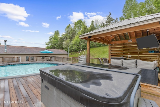 view of swimming pool with a hot tub, a fenced in pool, and a wooden deck