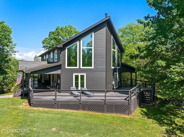 rear view of house featuring a lawn, a wooden deck, and stairway