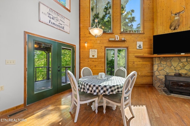 dining space featuring a towering ceiling, plenty of natural light, french doors, and visible vents