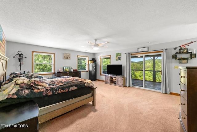bedroom featuring access to outside, a textured ceiling, light carpet, and ceiling fan
