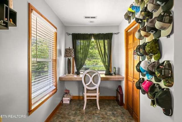 office featuring baseboards, visible vents, and a healthy amount of sunlight