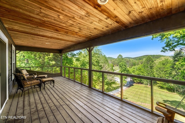 wooden terrace with a wooded view and a mountain view