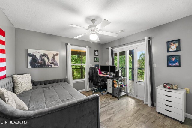 bedroom with a ceiling fan, a textured ceiling, access to exterior, wood finished floors, and baseboards