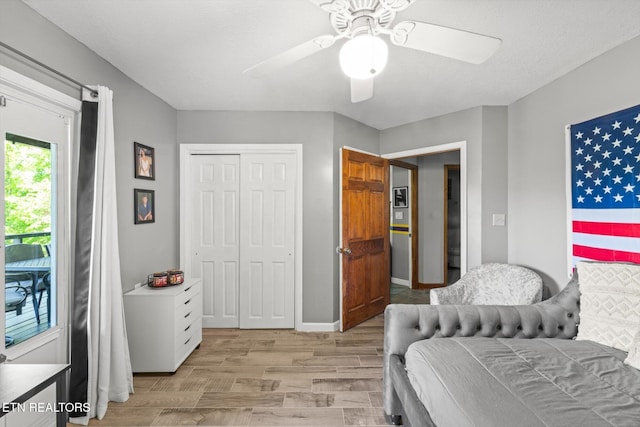 bedroom featuring light wood-type flooring, baseboards, ceiling fan, and a closet