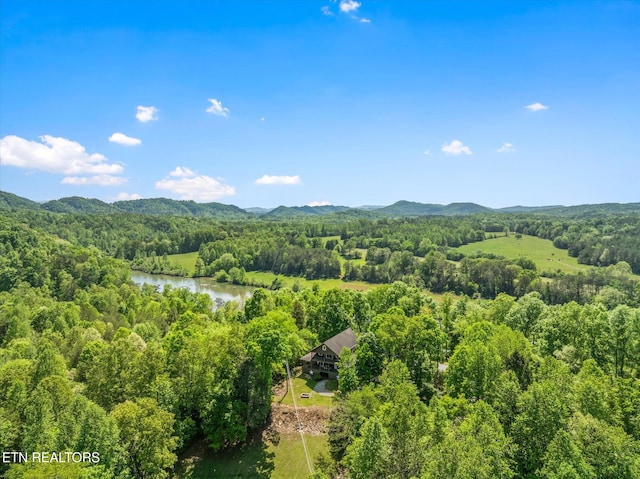 aerial view featuring a water and mountain view and a wooded view