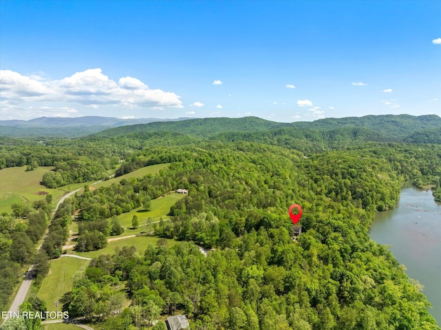birds eye view of property with a wooded view and a water and mountain view