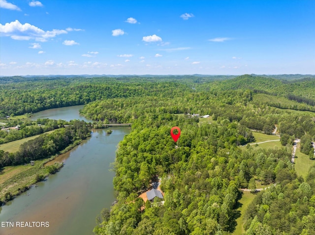 drone / aerial view with a water view and a wooded view