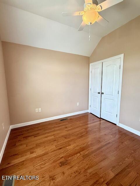 217 Loomis St, Tellico Plains, TN 37385 - unfurnished bedroom with visible vents, a closet, lofted ceiling, wood finished floors, and baseboards