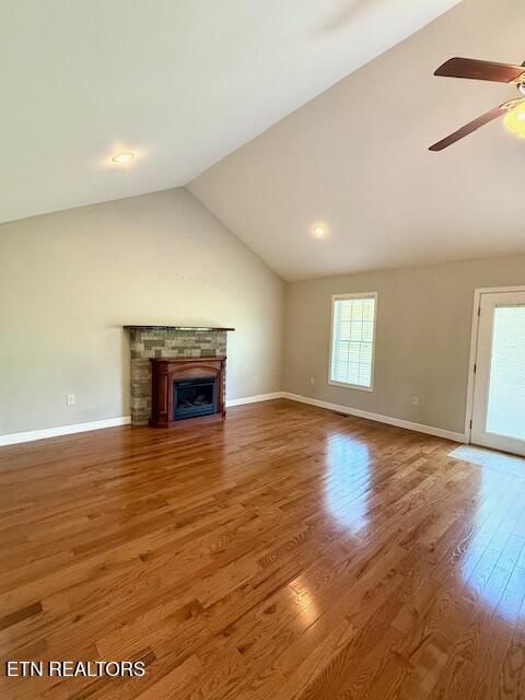 217 Loomis St, Tellico Plains, TN 37385 - unfurnished living room with ceiling fan, a fireplace, vaulted ceiling, wood finished floors, and baseboards