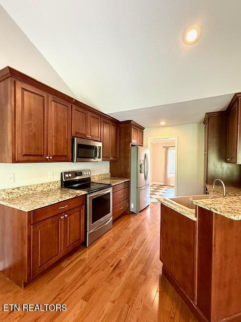 217 Loomis St, Tellico Plains, TN 37385 - kitchen featuring lofted ceiling, light stone countertops, a sink, light wood finished floors, and stainless steel appliances
