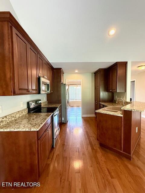 217 Loomis St, Tellico Plains, TN 37385 - kitchen with light stone counters, a sink, wood finished floors, and stainless steel appliances