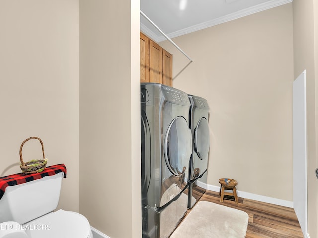 clothes washing area with independent washer and dryer, crown molding, cabinet space, baseboards, and wood finished floors