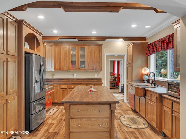 kitchen featuring stainless steel fridge, ornamental molding, light wood finished floors, and recessed lighting