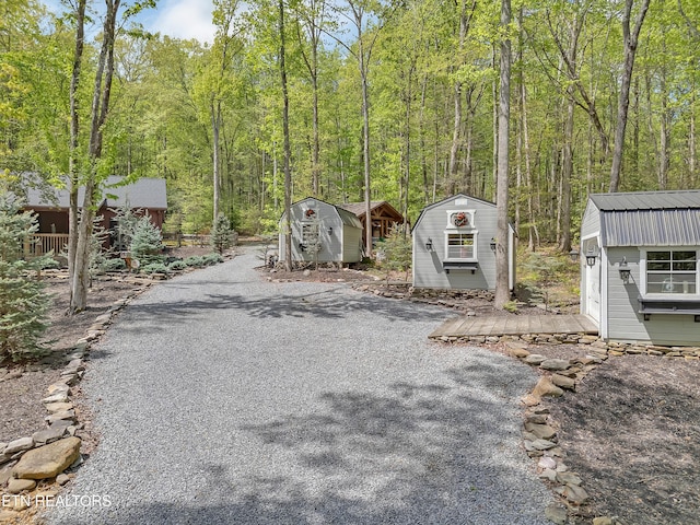 view of street featuring driveway and a forest view