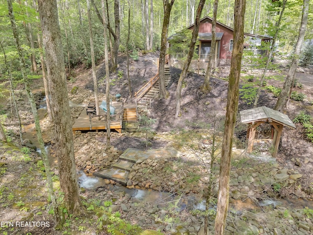 view of yard featuring a wooden deck and a forest view