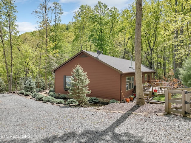 view of side of property with a wooded view