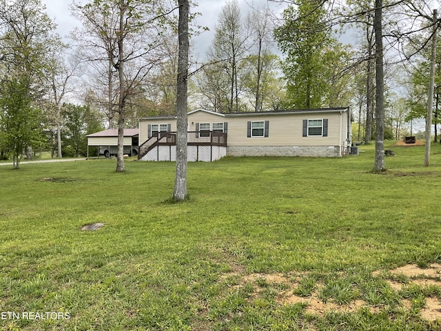 manufactured / mobile home featuring a wooden deck and a front lawn