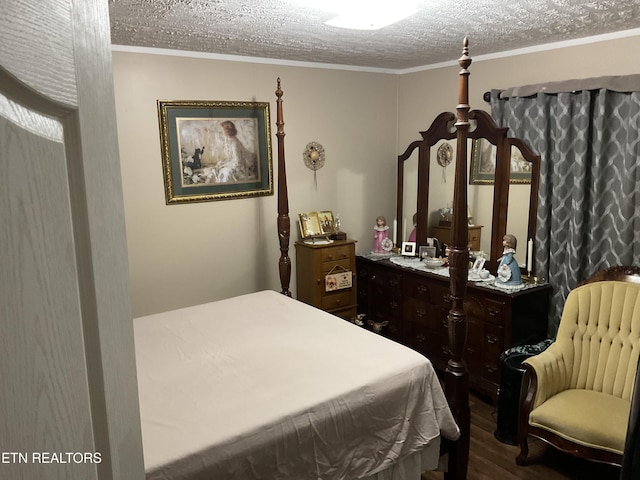 bedroom featuring ornamental molding, dark wood finished floors, and a textured ceiling