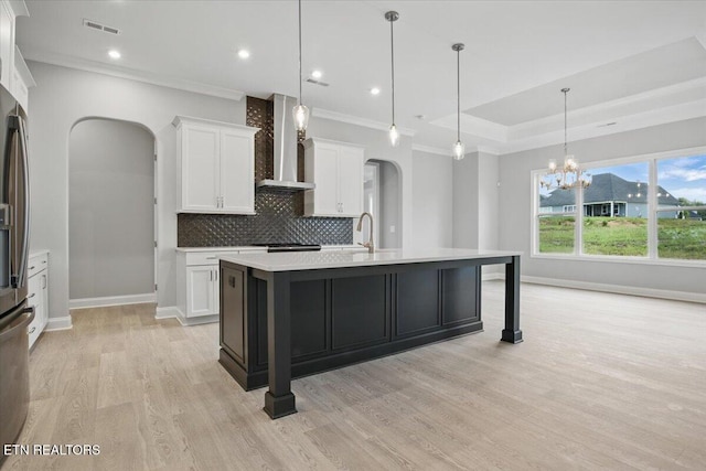 342 Bittersweet Ln, Lenoir City, TN 37771 - kitchen featuring wall chimney range hood, arched walkways, baseboards, ornamental molding, and light wood finished floors