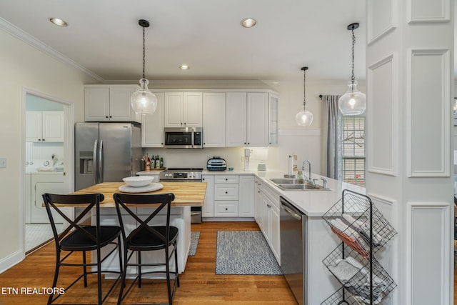 kitchen featuring a sink, ornamental molding, wooden counters, and stainless steel appliances