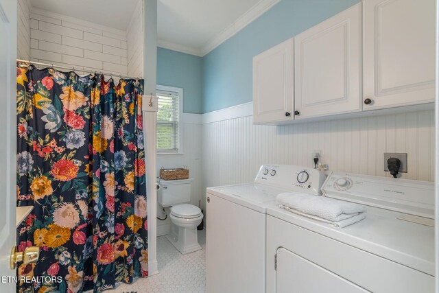 clothes washing area featuring crown molding, laundry area, tile patterned flooring, separate washer and dryer, and a wainscoted wall