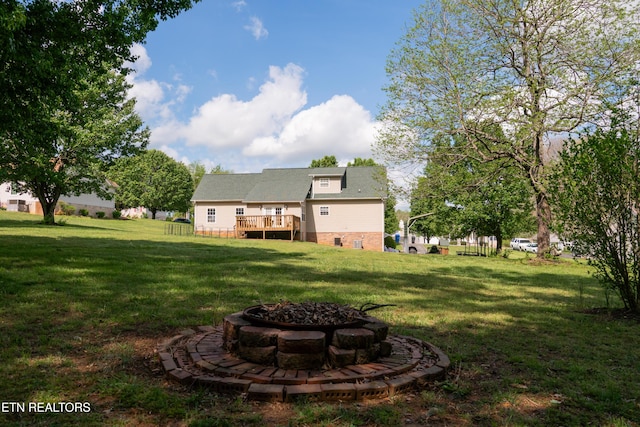 view of yard featuring an outdoor fire pit and a deck