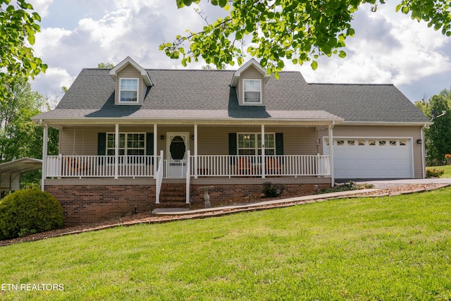 view of front of home featuring roof with shingles, covered porch, an attached garage, and a front lawn