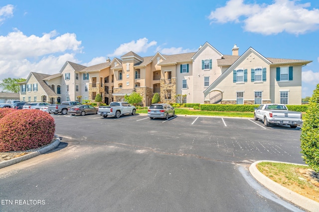 view of property with a residential view and uncovered parking