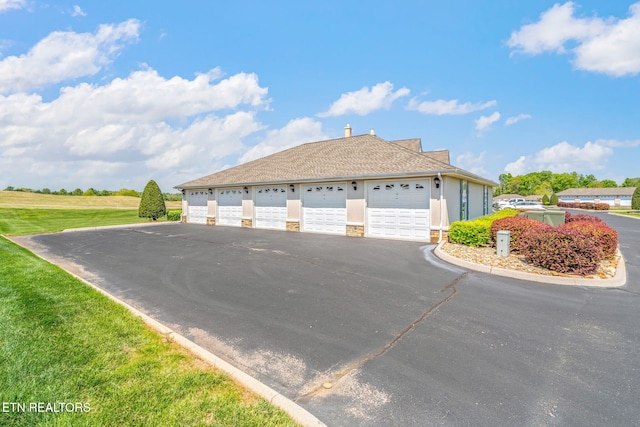exterior space featuring community garages, stucco siding, and stone siding