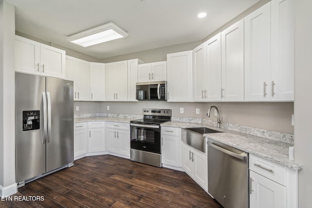 kitchen featuring white cabinets, stainless steel appliances, dark wood-style floors, and a sink
