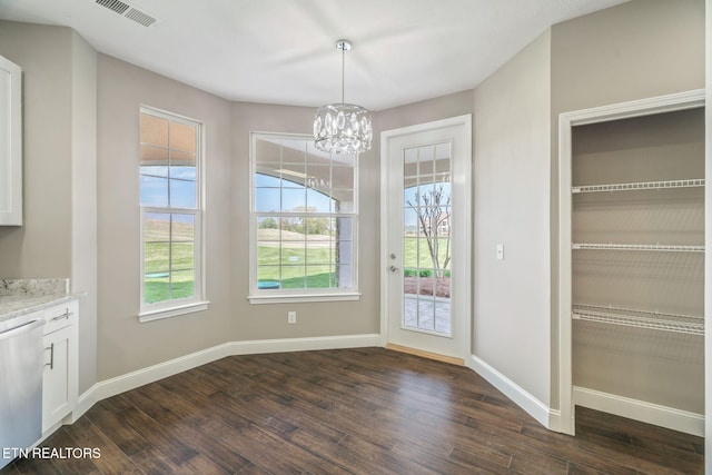 unfurnished dining area featuring visible vents, dark wood finished floors, baseboards, and a chandelier