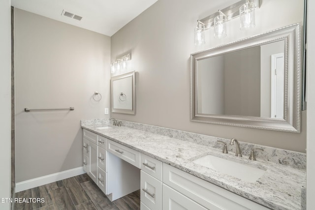 full bath with visible vents, a sink, baseboards, and double vanity