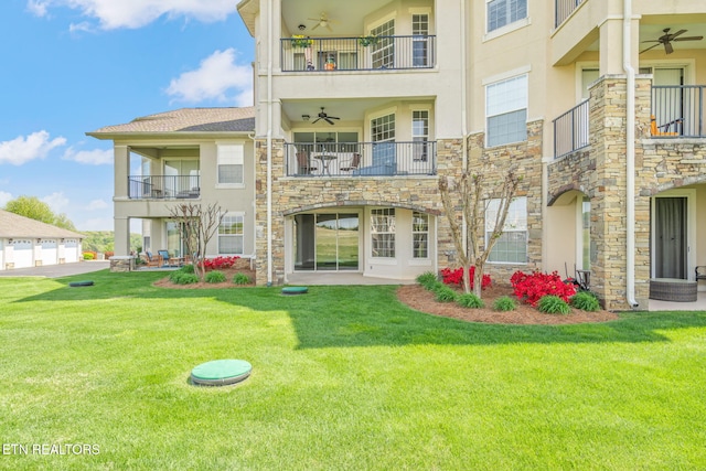back of property with a ceiling fan, stucco siding, a balcony, and stone siding