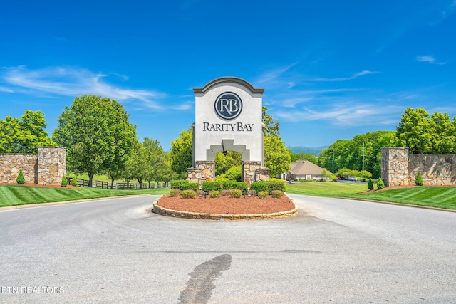 community / neighborhood sign with a mountain view and driveway