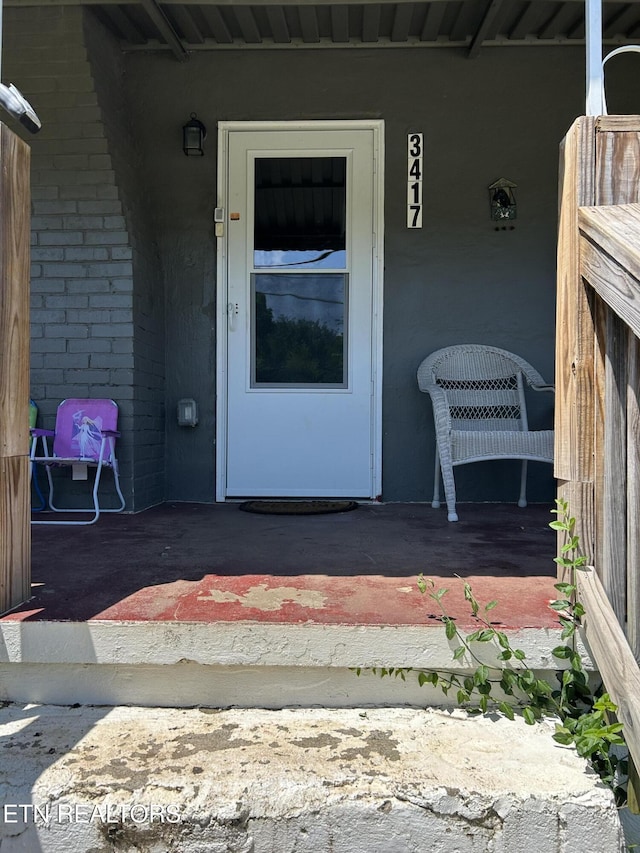 doorway to property featuring brick siding