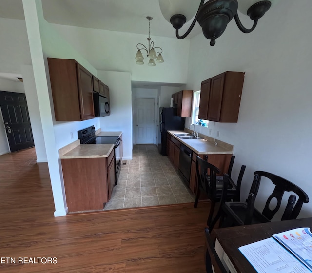 2094 NW Cecil Johnson Rd, Knoxville, TN 37921 - kitchen featuring black appliances, a chandelier, light countertops, light wood-type flooring, and a sink