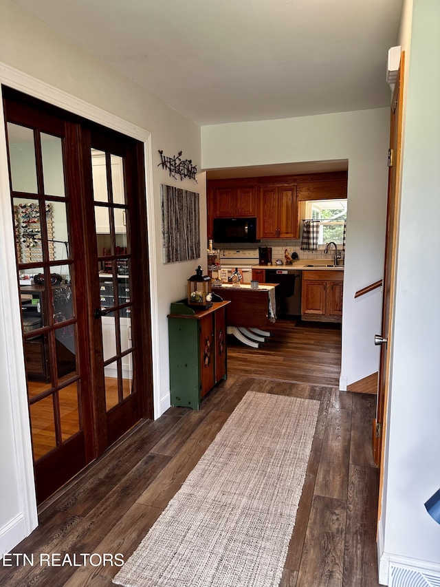interior space with french doors, a sink, baseboards, and dark wood-style floors