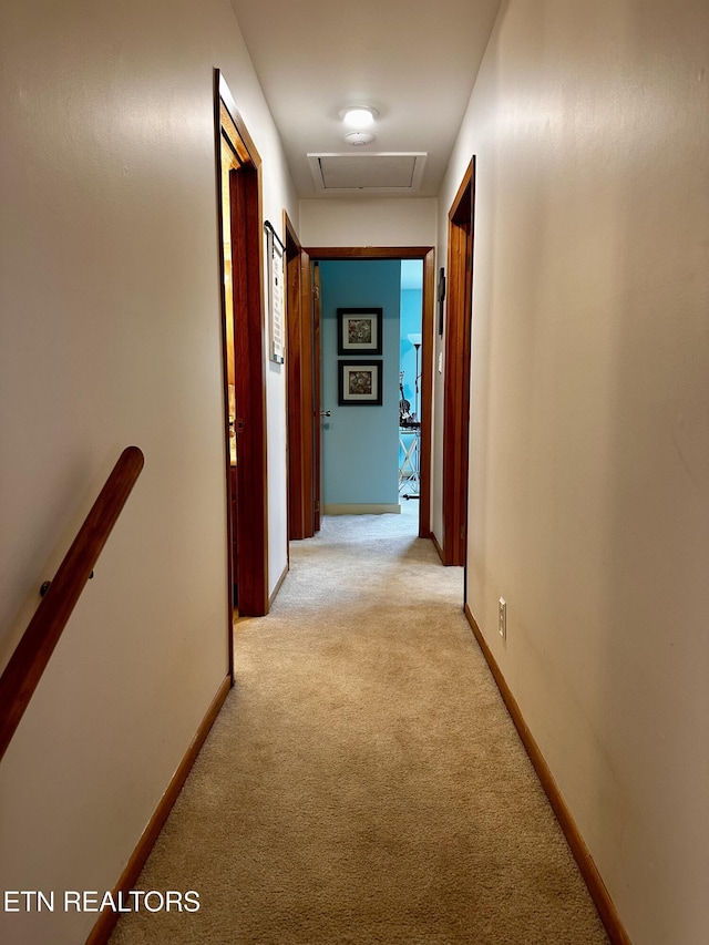 hall with light colored carpet, baseboards, an upstairs landing, and attic access