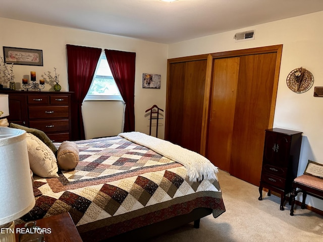 bedroom featuring visible vents and light carpet