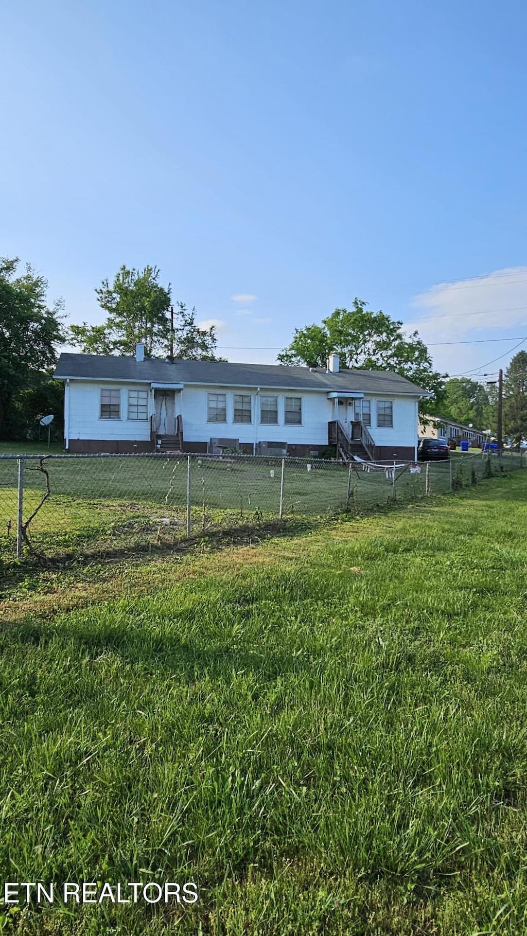 exterior space featuring fence private yard and a front lawn