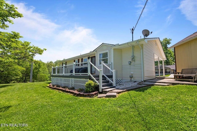 back of house featuring a wooden deck and a yard