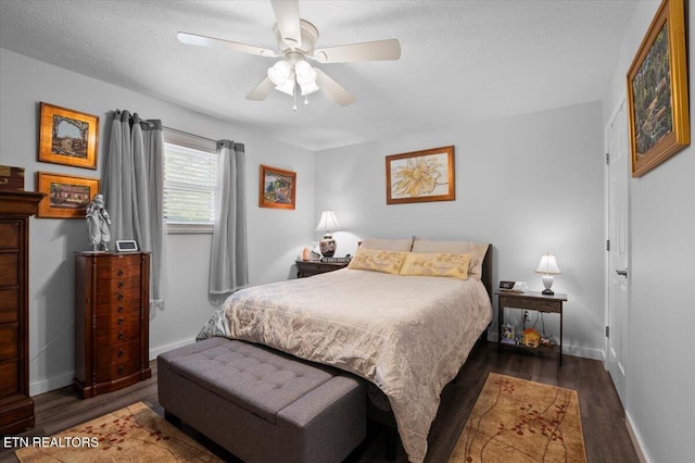 bedroom with baseboards, a textured ceiling, and wood finished floors