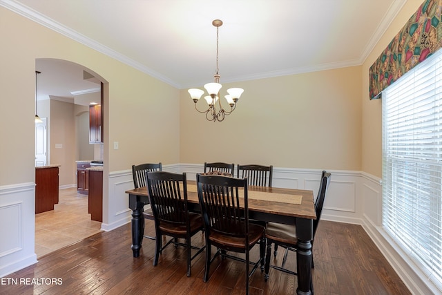 1827 Autumn Bluff Rd, Knoxville, TN 37932 - dining area with a chandelier, crown molding, dark wood-type flooring, arched walkways, and wainscoting