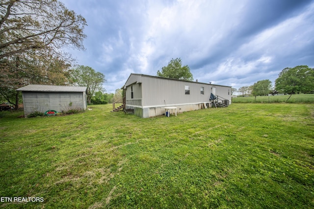 back of house featuring a lawn and an outdoor structure