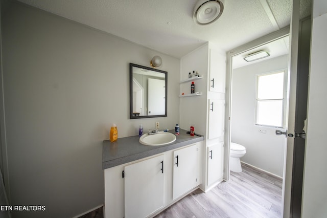 bathroom featuring vanity, a textured ceiling, wood finished floors, and toilet