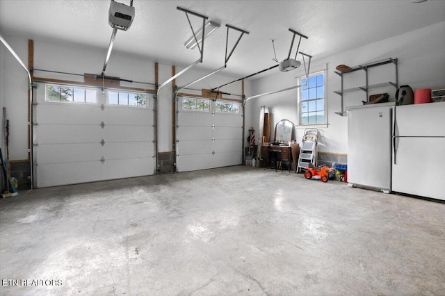 garage with freestanding refrigerator and a garage door opener