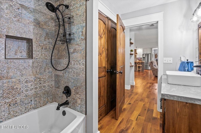 full bath featuring shower / bath combination, vanity, and wood finished floors