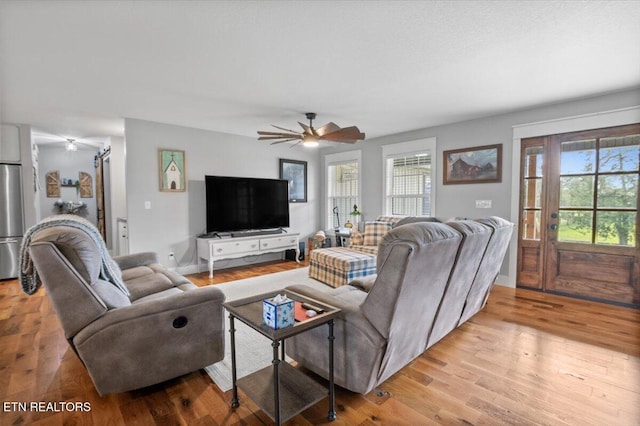 living room featuring light wood finished floors and ceiling fan